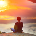 Woman meditating at sunset
