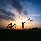 Kid with kite at sunset