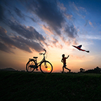 kid with bike and kite at sunset